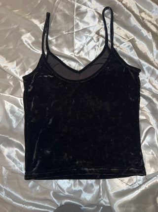 Black velvet bodysuit on a textured white surface