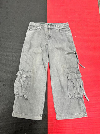 Gray jeans laid flat on a red and black surface